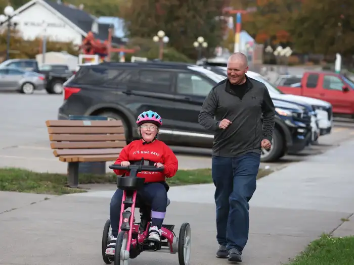 Kinsley and her dad on her bike for the first time